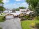 View of beautiful home featuring an attached garage, well manicured landscaping and circular driveway at 11200 Lane Park Rd, Tavares, FL 32778