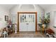 Bright foyer with tile flooring, a decorative door and stylish floral arrangements at 11200 Lane Park Rd, Tavares, FL 32778