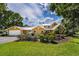 Charming two-story home with a well-manicured lawn, colorful flower beds, and attached garage at 11200 Lane Park Rd, Tavares, FL 32778