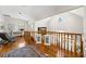 Open hallway featuring wooden railing, wood floors, and a decorative transom window at 11200 Lane Park Rd, Tavares, FL 32778