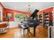 Elegant music room with a grand piano, natural light, and hardwood floors at 11200 Lane Park Rd, Tavares, FL 32778