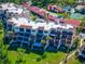 Aerial view showcasing condo building with balconies and red tile roof amidst green landscaping, and walking paths at 1162 Carmel Cir # 440, Casselberry, FL 32707
