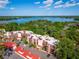 Scenic aerial view of condo buildings surrounded by lush greenery, with a glimpse of the lake in the distance at 1162 Carmel Cir # 440, Casselberry, FL 32707