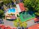 Aerial view of the community featuring a pool, hot tub, tennis court, and parking area surrounded by lush landscaping at 1162 Carmel Cir # 440, Casselberry, FL 32707
