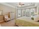 Bright bedroom featuring a four-poster bed, neutral walls, and abundant natural light from large windows overlooking the pool at 12614 Hawkstone Dr, Windermere, FL 34786