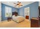 Comfortable bedroom with hardwood furniture, overhead fan, natural light and attached bathroom at 12614 Hawkstone Dr, Windermere, FL 34786