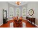 Formal dining room with hardwood floors, wood table and chairs, and sideboard with round mirror at 12614 Hawkstone Dr, Windermere, FL 34786