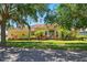 Charming yellow house with a red tile roof, complemented by lush landscaping and mature trees at 12614 Hawkstone Dr, Windermere, FL 34786