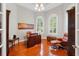 Comfortable home office with hardwood floors, arched windows with white shutters, and leather furniture at 12614 Hawkstone Dr, Windermere, FL 34786