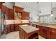 Gourmet kitchen with dark wood cabinetry, granite countertops, a center island, and stainless steel appliances at 12614 Hawkstone Dr, Windermere, FL 34786