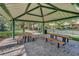Community pavilion featuring picnic tables and charcoal grill, all resting on a brick surface at 12614 Hawkstone Dr, Windermere, FL 34786