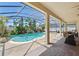 Stunning screened-in pool area with a waterfall feature, lush landscaping, and inviting seating at 12614 Hawkstone Dr, Windermere, FL 34786