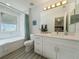 Bright bathroom with white cabinets, a large mirror, and a shower/tub combination at 130 Palermo St, Davenport, FL 33897