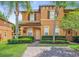 Inviting two-story townhome featuring brick-paved drive, landscaping, and covered porch at 130 Palermo St, Davenport, FL 33897