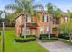 Two-story townhome with brick-paved drive, mature landscaping, and covered entry at 130 Palermo St, Davenport, FL 33897