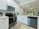 Well-lit kitchen featuring stainless steel appliances and open view to living space at 130 Palermo St, Davenport, FL 33897