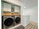 Convenient laundry area with modern washer and dryer units, built-in cabinets, and a butcher block countertop at 130 Palermo St, Davenport, FL 33897
