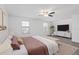 Staged bedroom is enhanced by wood-look floors, ceiling fan, and contemporary furnishings at 131 Heritage Park St, Winter Springs, FL 32708