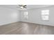 Spacious bedroom boasts two windows, a ceiling fan, and wood-look flooring at 131 Heritage Park St, Winter Springs, FL 32708