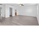 Large bedroom with ceiling fan, wood-look floors, and doorways to a closet and bathroom at 131 Heritage Park St, Winter Springs, FL 32708