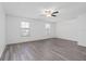 Large bedroom featuring two windows, a ceiling fan, and wood-look flooring at 131 Heritage Park St, Winter Springs, FL 32708