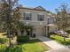 Exterior of a two-story grey townhome featuring a front yard, driveway, attached garage, and a charming entrance at 131 Heritage Park St, Winter Springs, FL 32708