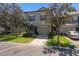 View of a grey townhome with a driveway, green lawn, and small front porch showing the home's facade and curb appeal at 131 Heritage Park St, Winter Springs, FL 32708