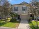 Exterior view of a charming two-story grey townhome, complemented by a well-kept lawn and easy parking at 131 Heritage Park St, Winter Springs, FL 32708