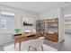 Bright home office with wood-look floors, bookshelves, and a large window with views at 131 Heritage Park St, Winter Springs, FL 32708