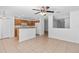 Open-concept kitchen features wood cabinetry, white appliances, and breakfast bar adjacent to the dining and living area at 131 Heritage Park St, Winter Springs, FL 32708