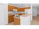 Bright kitchen features wood cabinets, white appliances, stainless sink and breakfast bar at 131 Heritage Park St, Winter Springs, FL 32708