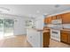 Functional kitchen with a breakfast bar, white appliances, and wood cabinets at 131 Heritage Park St, Winter Springs, FL 32708
