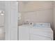Laundry room features white washer and dryer, with built in shelves, and white door at 131 Heritage Park St, Winter Springs, FL 32708