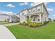 Side view of a two-story home with a well-manicured lawn and complementary landscaping at 13640 Haulover Beach Ln, Orlando, FL 32827