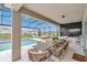 Covered patio with outdoor kitchen, grill, dining area, and screened-in pool with beautiful water view at 13640 Haulover Beach Ln, Orlando, FL 32827