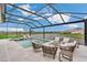 Screened-in pool and patio with a tranquil lake view and comfortable outdoor seating at 13640 Haulover Beach Ln, Orlando, FL 32827