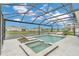 Relaxing screened-in pool with a spa and sun loungers overlooking the backyard and lake at 13640 Haulover Beach Ln, Orlando, FL 32827