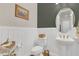 Stylish powder room with white wainscoting, modern fixtures, and decorative accents at 13640 Haulover Beach Ln, Orlando, FL 32827