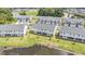 Aerial view showcases modern townhomes, a peaceful pond, and lush green spaces in a residential area at 1438 Brookdale Ct, Oviedo, FL 32765