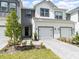 A close view displays a townhome with two-car garage, pavers, and coordinated landscaping at 1438 Brookdale Ct, Oviedo, FL 32765