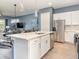 An open kitchen has bar seating and an island overlooking the large living spaces at 1438 Brookdale Ct, Oviedo, FL 32765