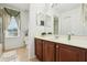 Well-lit bathroom featuring wood vanity, sink, and a large mirror with natural light at 14819 Braywood Trl, Orlando, FL 32824