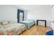 Cozy bedroom with two beds, light hardwood floors, and a sunny window with curtains at 14819 Braywood Trl, Orlando, FL 32824