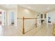Upstairs hallway with decorative railing and views into bedrooms and workout room at 14819 Braywood Trl, Orlando, FL 32824