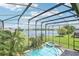 Screened pool overlooks lush backyard and serene lake, offering the perfect oasis at 14819 Braywood Trl, Orlando, FL 32824