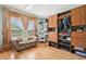 Organized walk-in closet with custom shelving, seating area, and a large bright window with wood flooring at 14819 Braywood Trl, Orlando, FL 32824