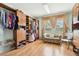 Spacious walk-in closet with custom shelving, seating area, and a large window with wood flooring at 14819 Braywood Trl, Orlando, FL 32824