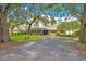 Attractive single-story home with a brick facade, surrounded by lush greenery and mature trees at 1511 Crestline St, Orlando, FL 32806