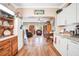Open-concept living room with hardwood floors, leading to the kitchen featuring white cabinets and granite countertops at 1511 Crestline St, Orlando, FL 32806