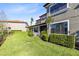 Beautiful backyard featuring green grass, trimmed hedges, and the building's exterior at 1561 Corkery Ct, Winter Springs, FL 32708